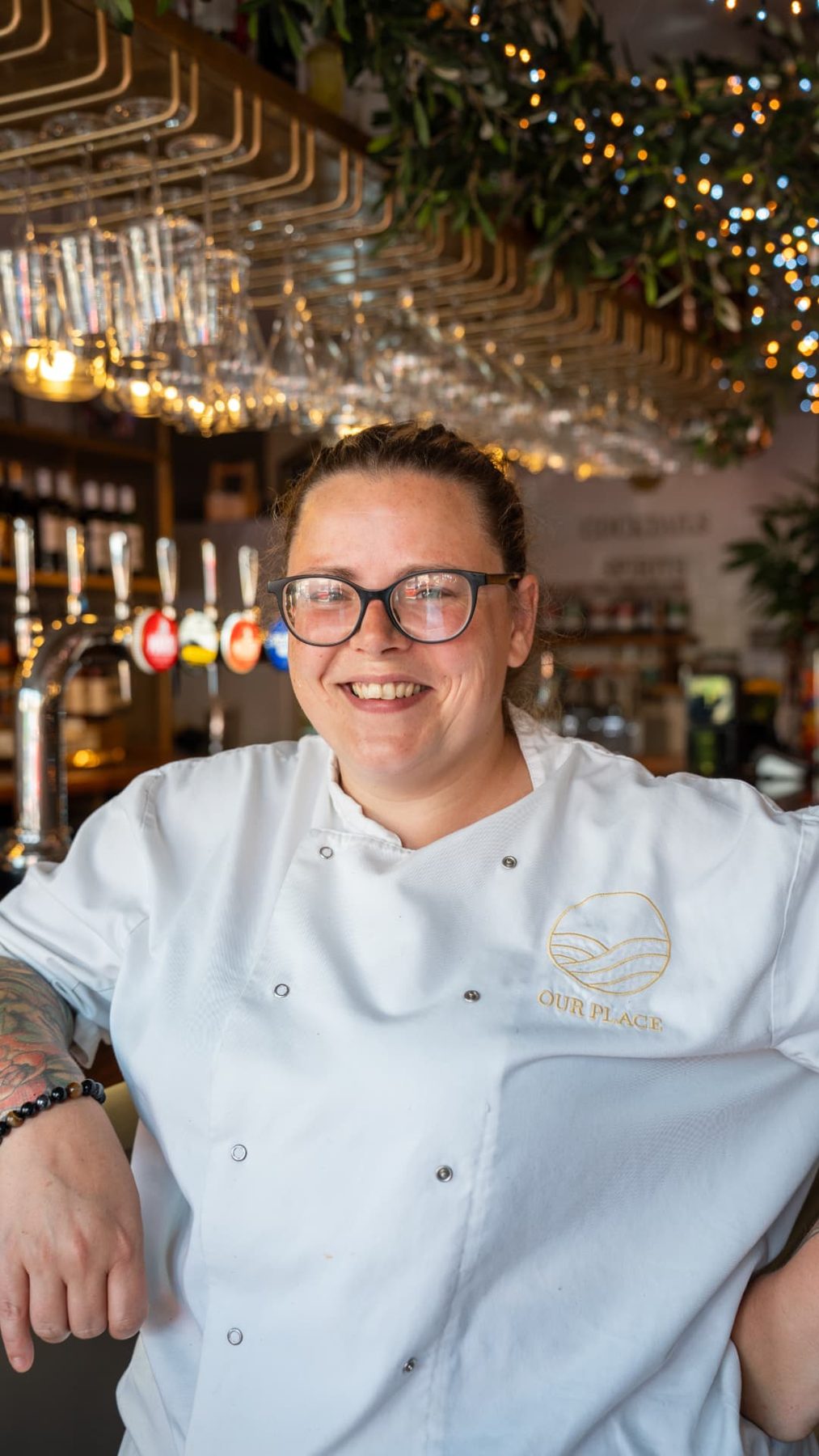 Our Place head chef smiling at the restaurant bar